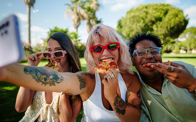 three friends eating pizza
