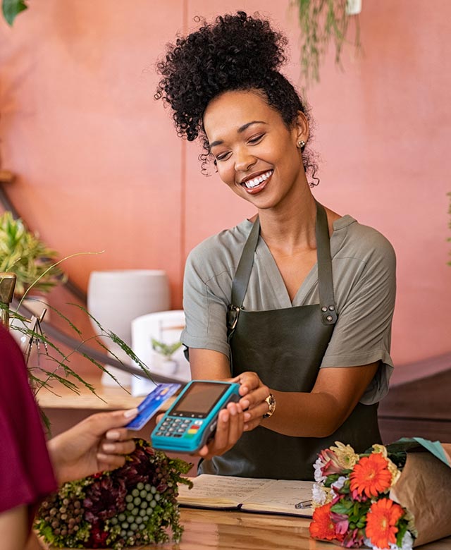 person paying with card at a flower shop