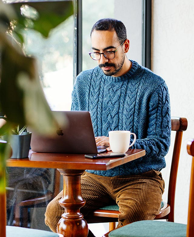 man using laptop at cafe